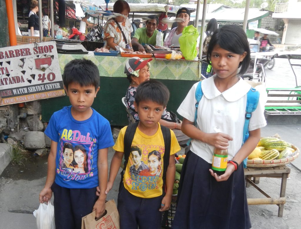 three children in front of a store