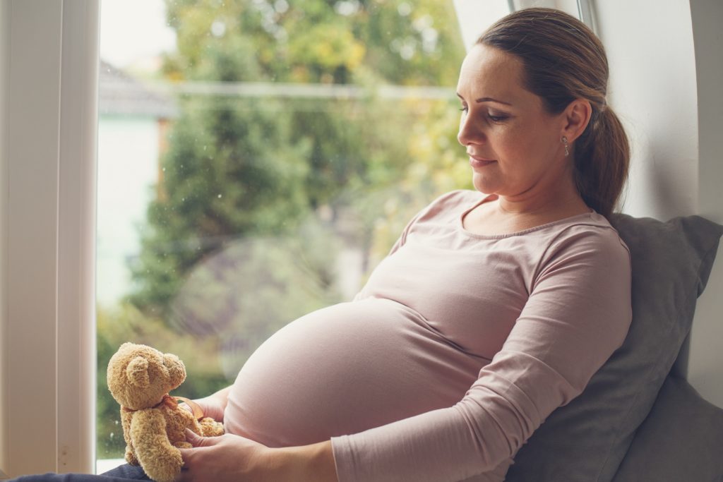 pregnant woman holding teddy bear
