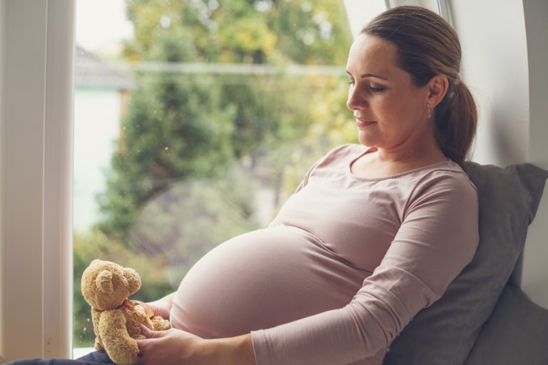 pregnant woman holding teddy bear