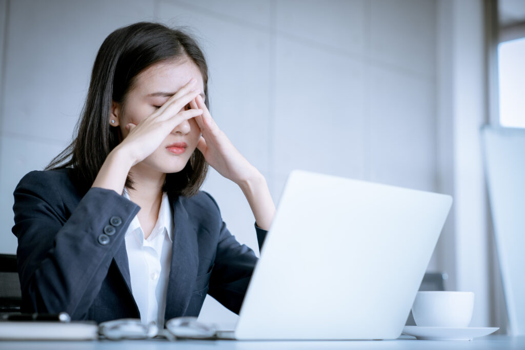 Asian business woman headache stressed because of work mistake problems about profit losses to be risk for fired from her job Asian business woman headache stressed because of work mistake problems about profit losses to be risk for fired from her job